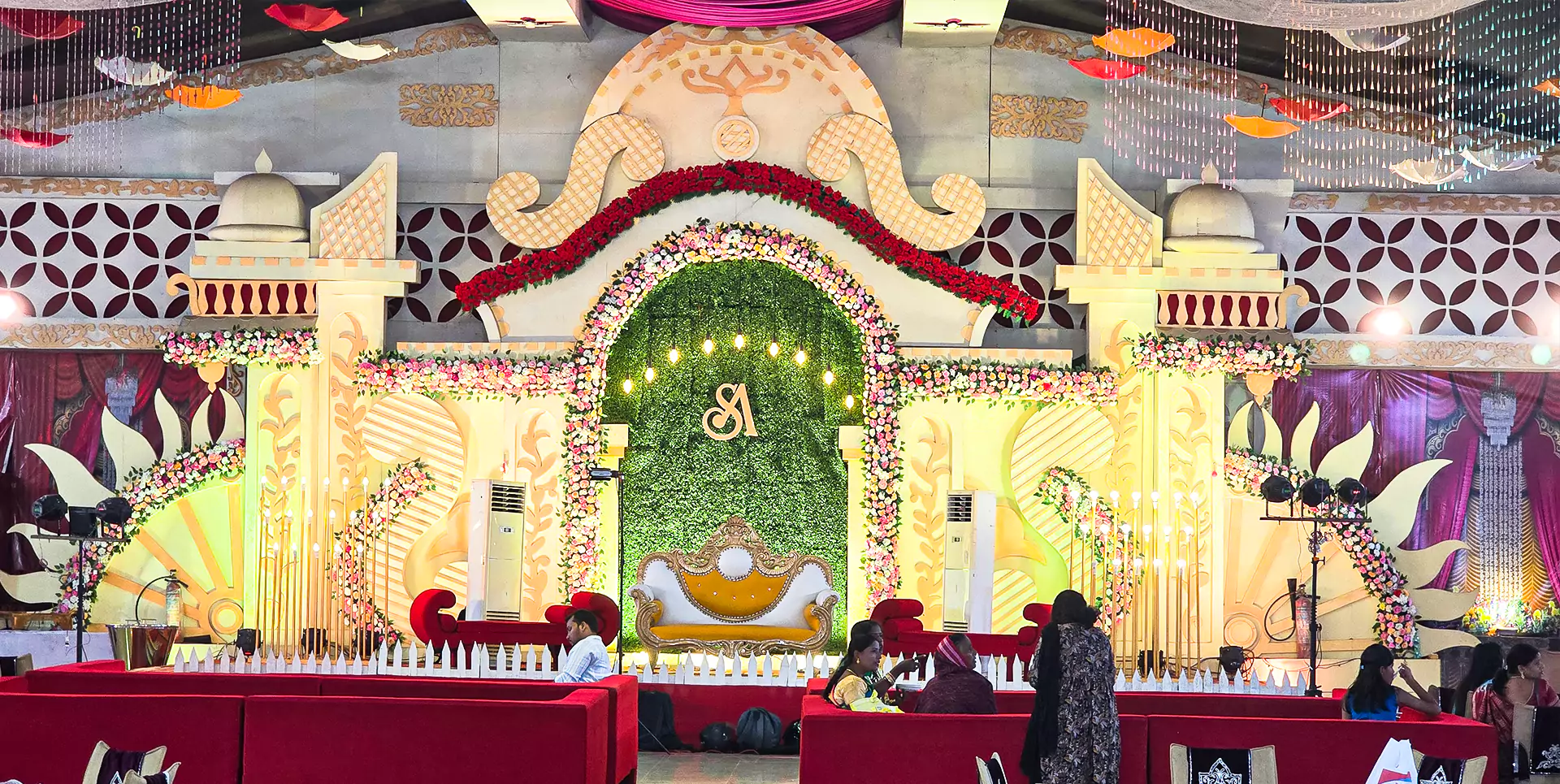 Decorated wedding stage with floral arrangements and elegant lighting for ceremonies and receptions